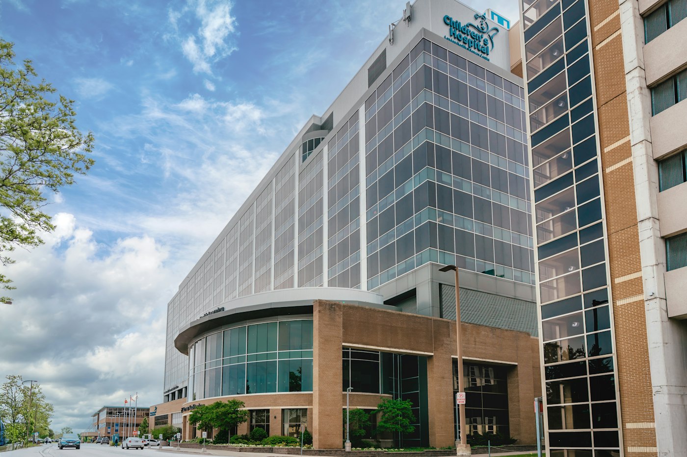Modern glass building with curved entrance under sky.